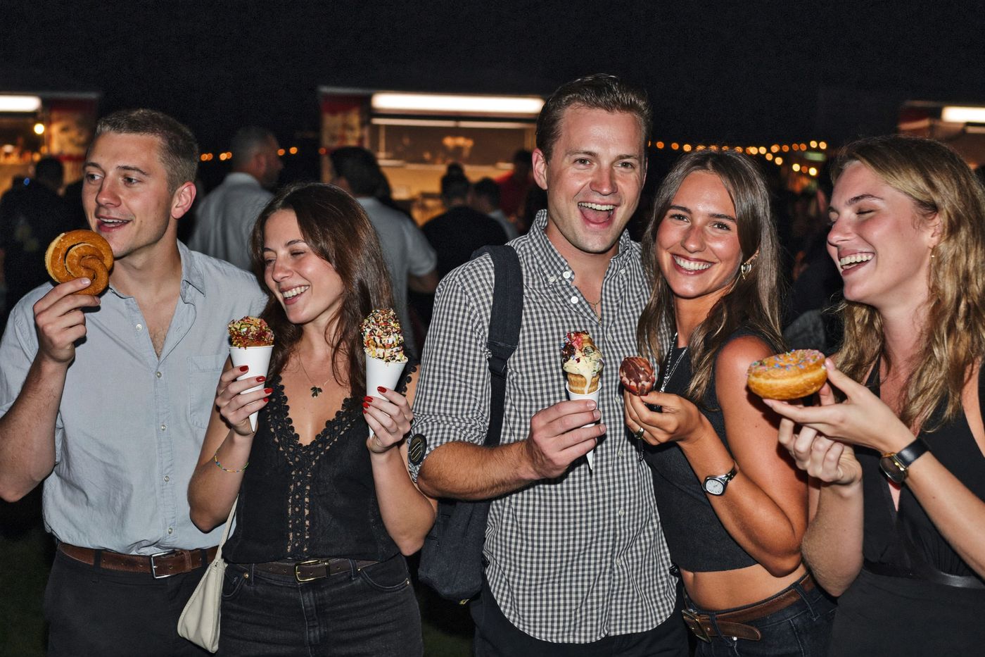 Friends holding soft serve, donuts and churros at a Brisbane dessert truck event