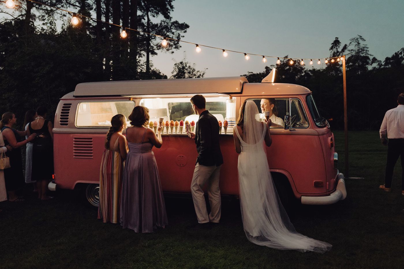 Guests queueing at an ice cream van at a twilight garden party