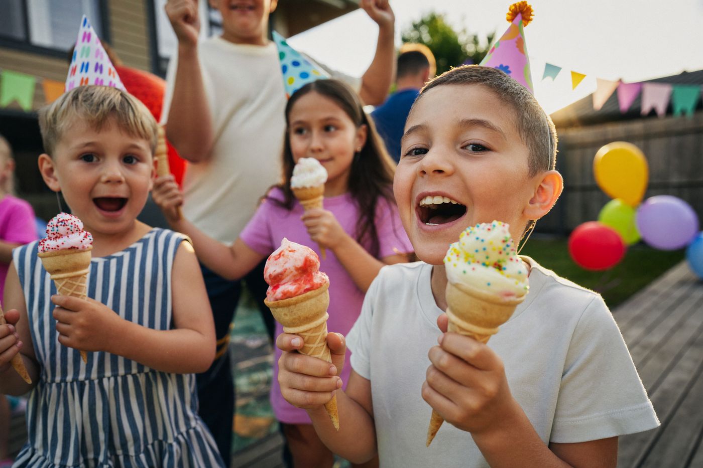 Children enjoying soft-serve cones at a backyard birthday party
