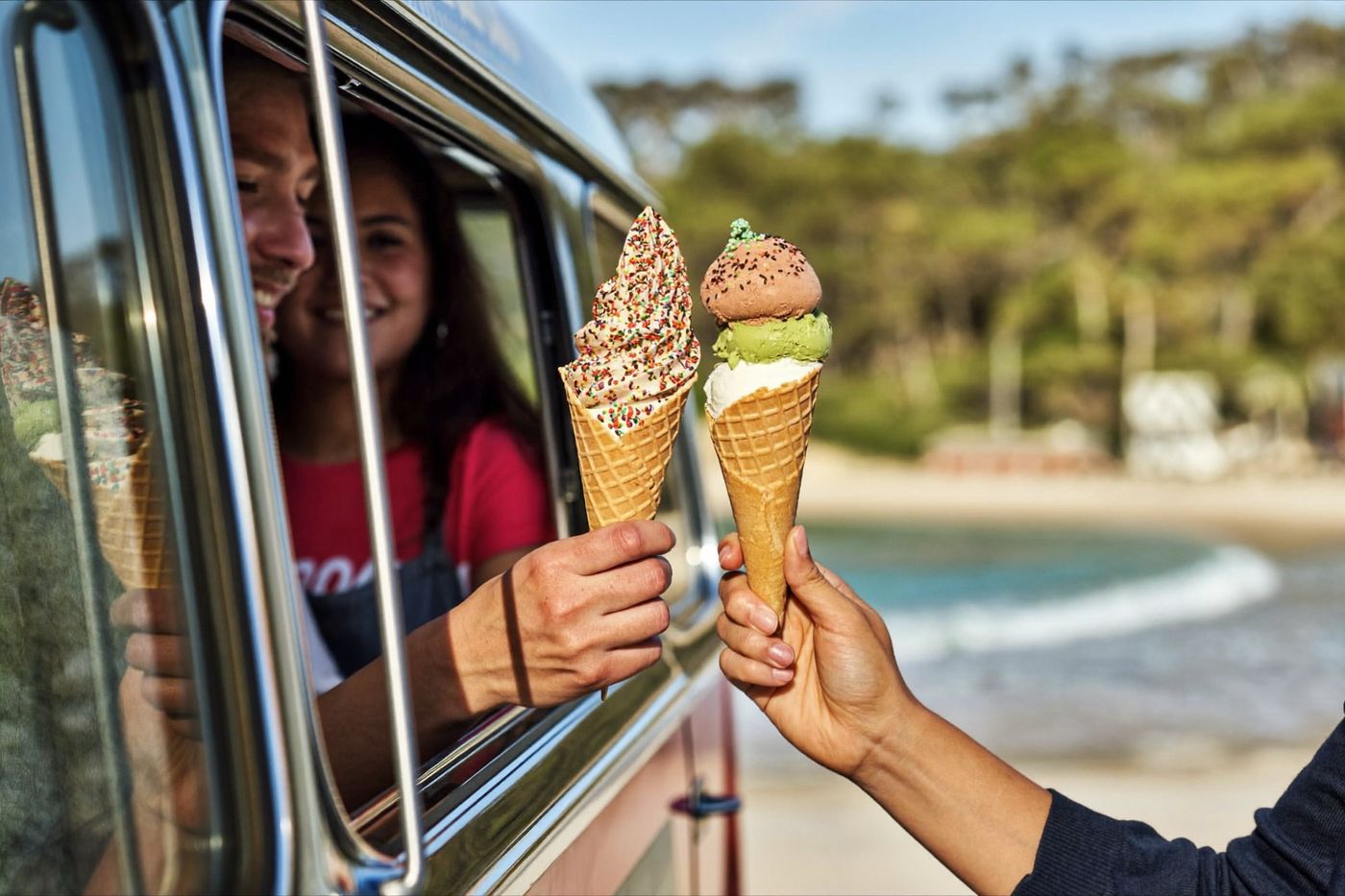 Soft-serve cones being handed from the ice cream van serving window on the Gold Coast